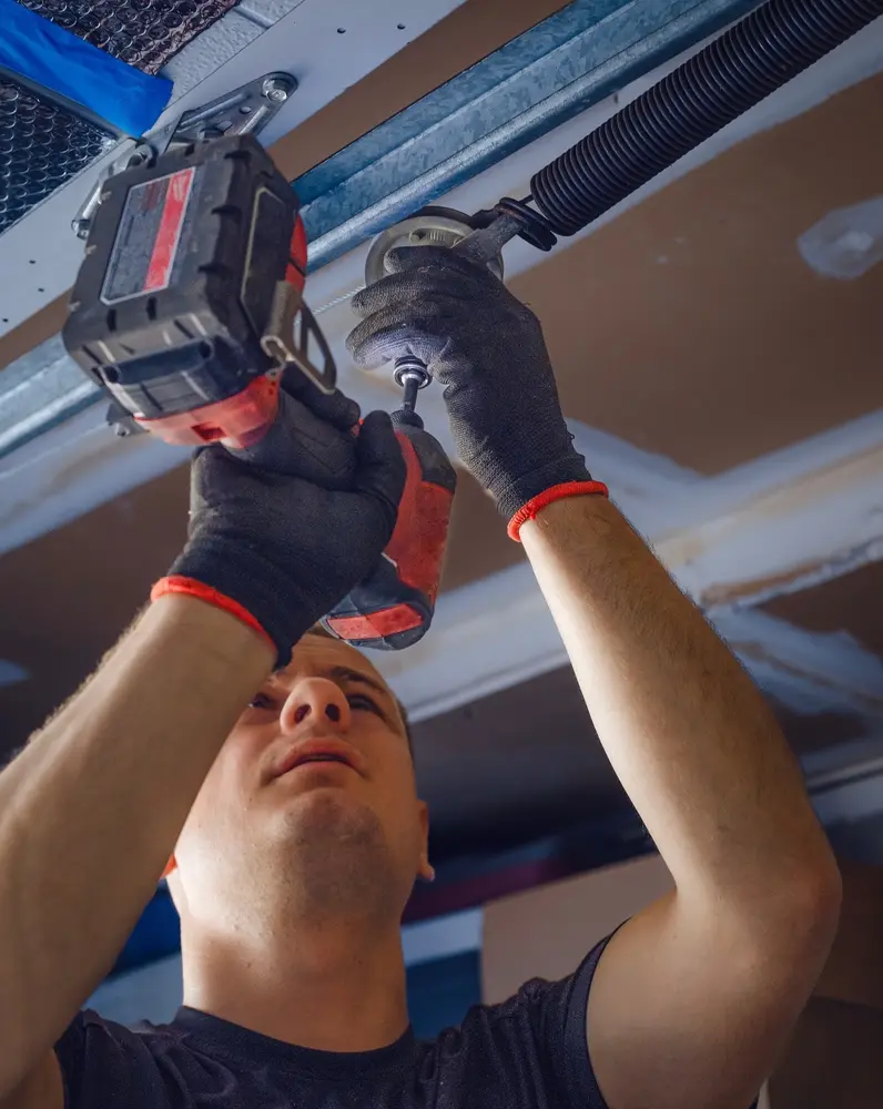 Technician performing garage door spring repair on a residential garage in Baton Rouge, LA